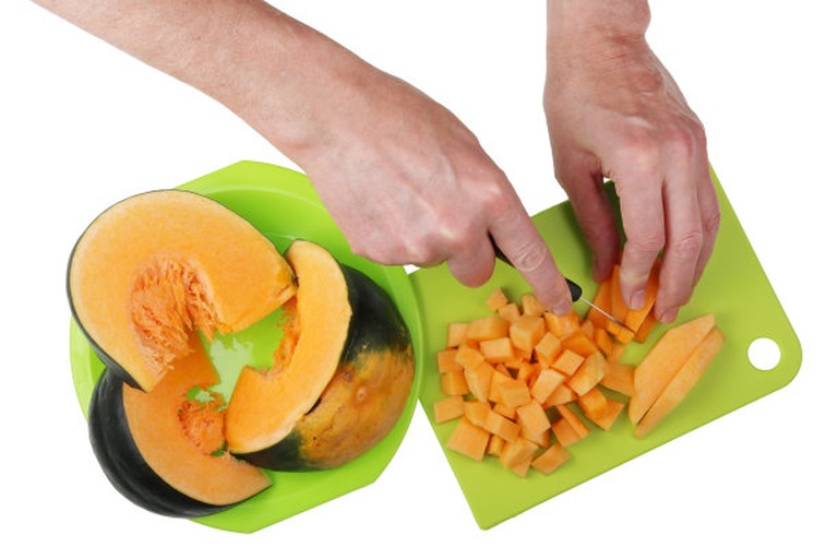 女性正在厨房检查切开的南瓜是否变质