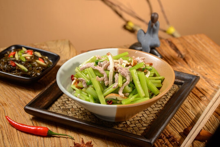 高清特写:香芹炒肉丝成品图,展示芹菜斜切段的脆嫩质感、肉丝的柔滑纹理、锅气形成的自然油亮光泽,背景为中式铁锅,体现‘大火快炒’的烹饪状态 香芹炒肉丝特写:翠绿芹段与粉嫩肉丝交织,锅中油光锃亮,蒜末金黄未焦,热气升腾