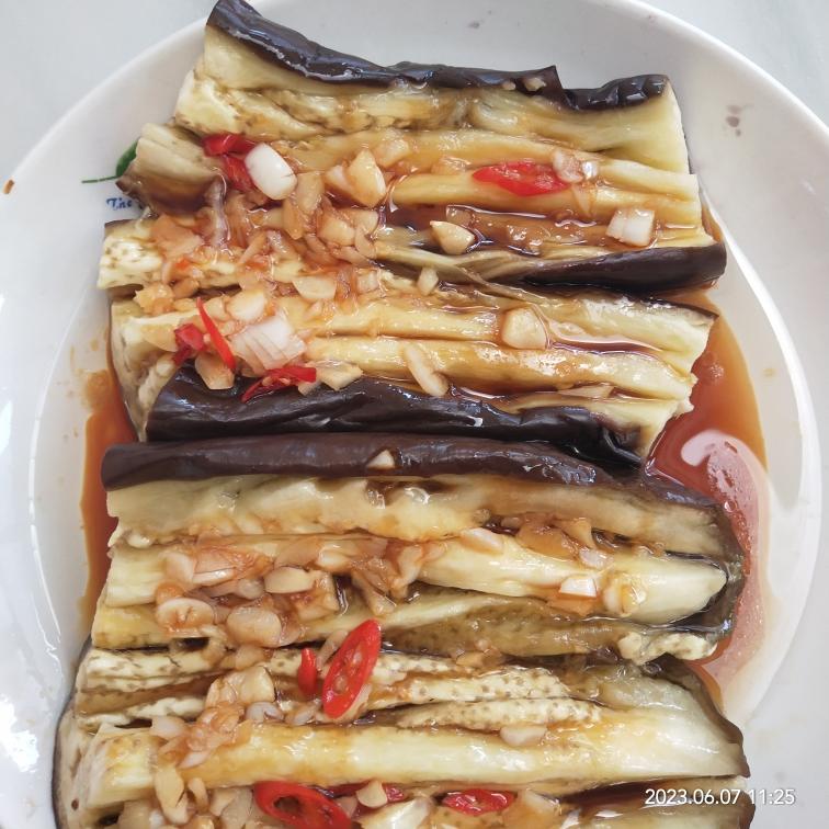 家庭厨房中蒸制完成的蒜蓉茄子摆盘