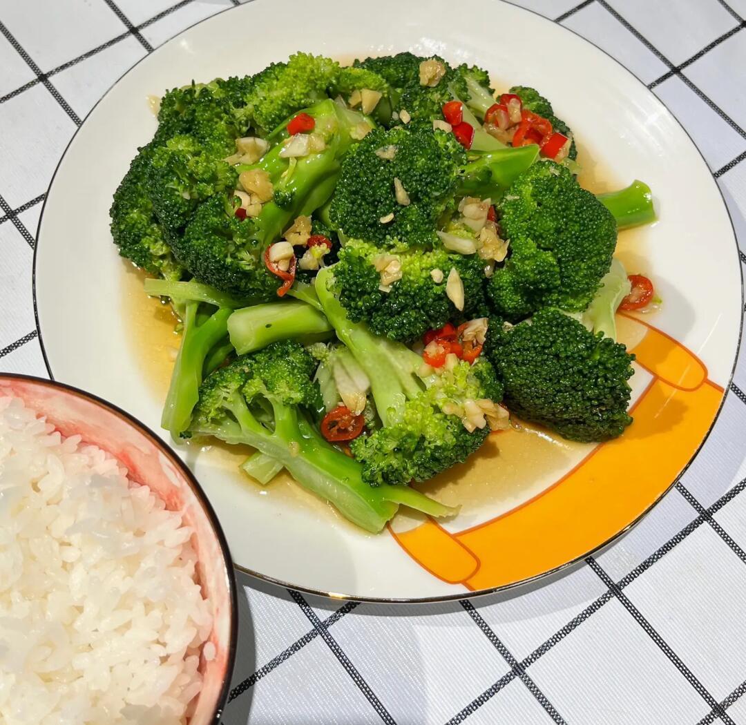 俯拍摆盘图:左上角为翠绿西兰花,右下为浅褐色糙米饭,中央堆叠着油亮牛肉与碧绿螺丝椒的牛肉炒螺丝椒,色彩鲜明,质感分明,体现健康轻食理念 牛肉炒螺丝椒搭配糙米饭与西兰花的轻食碗