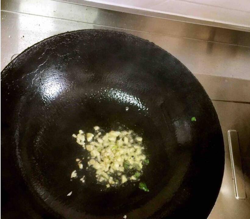 家庭厨房中正在翻炒烟薯叶的场景