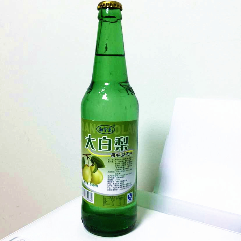 年轻人聚会场景中桌上摆放大白梨汽水与调酒杯混合搭配