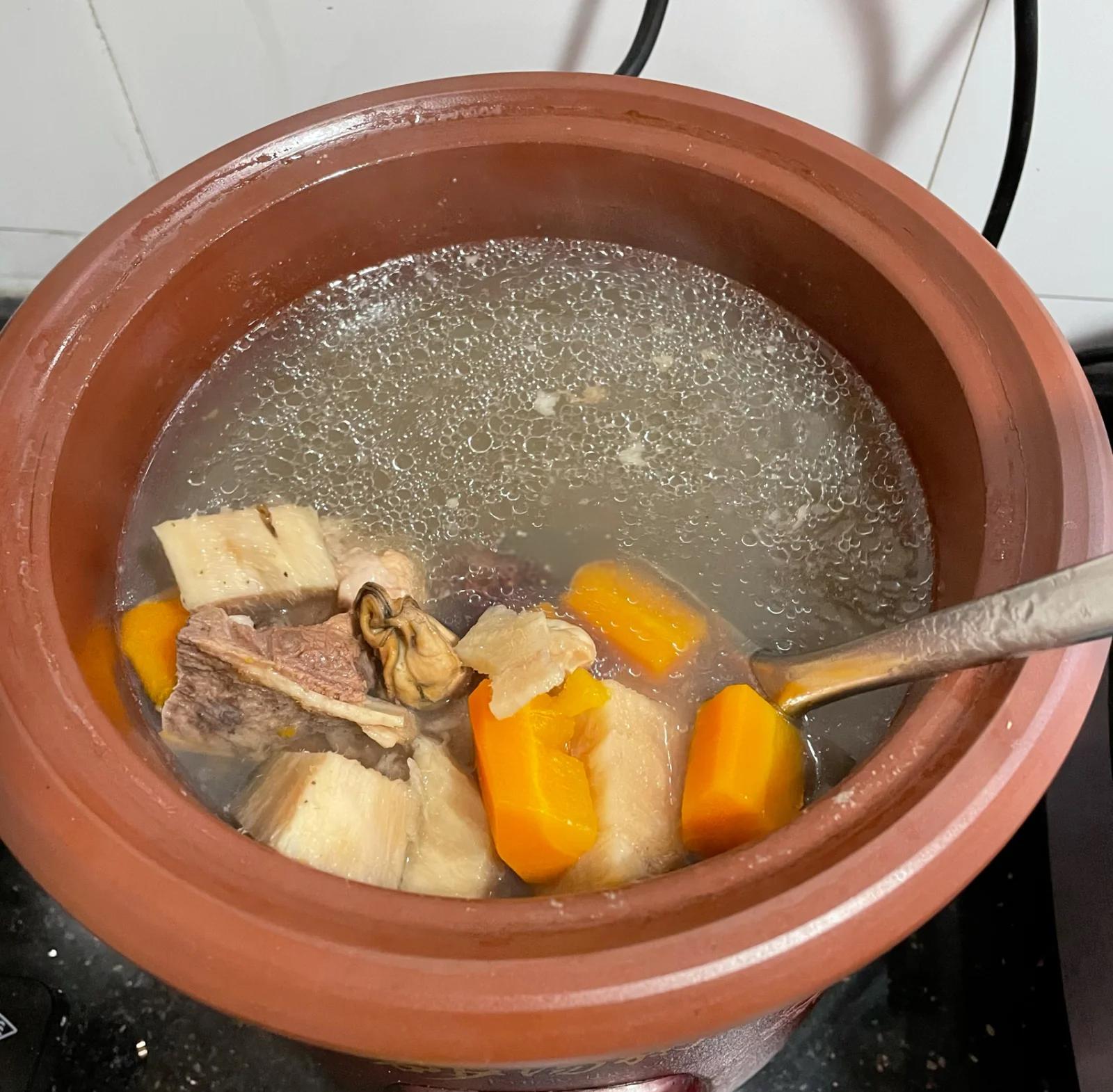 砂锅中正在焖煮的南乳粉葛，汤汁微沸，粉葛块浸润在红褐色酱汁中，散发热气