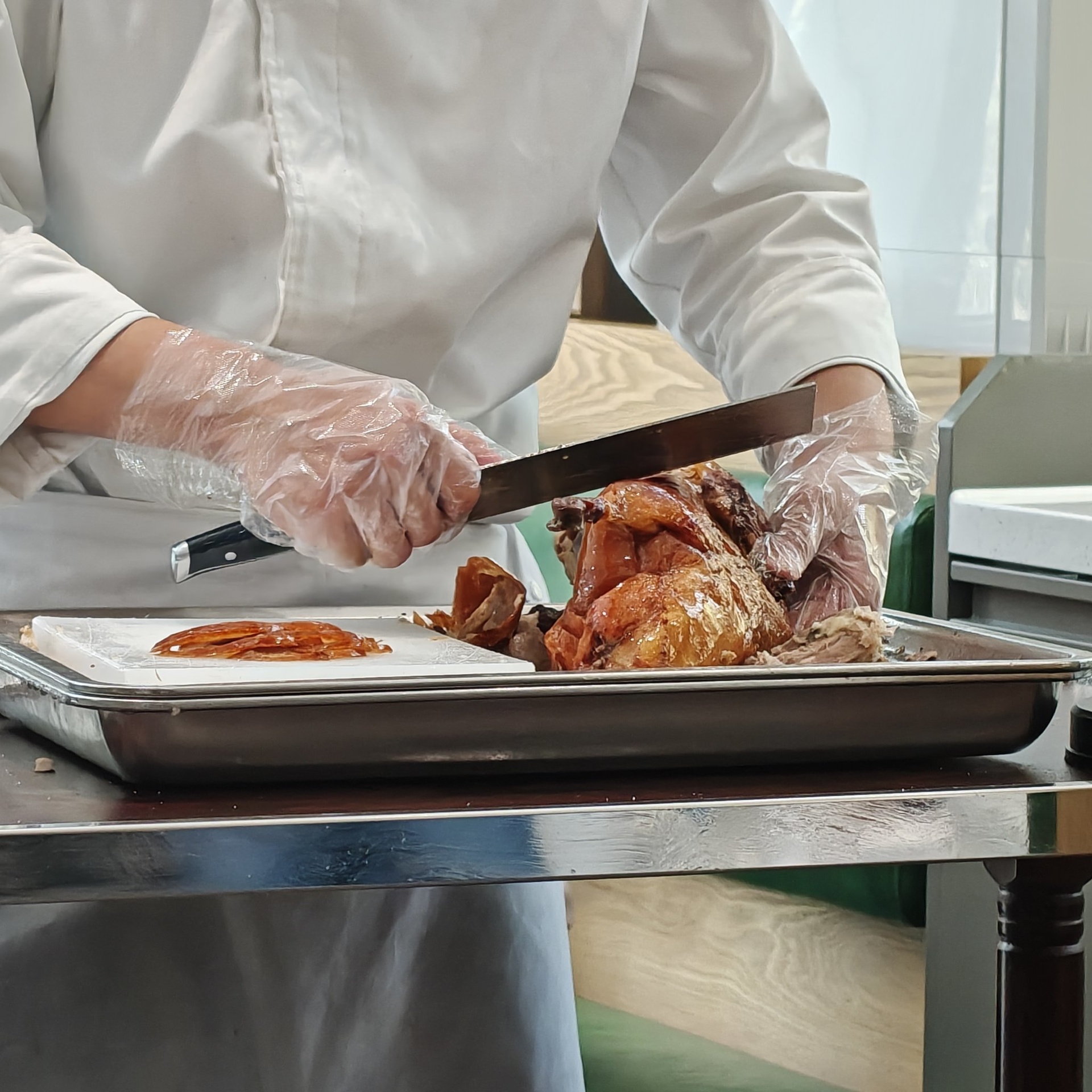 一名厨师正在用软毛刷仔细清洗一排整齐摆放的鸭蛋,旁边有装有白酒的小碗和干净的竹制晾架,背景为厨房操作台,光线明亮 清洗与消毒过程