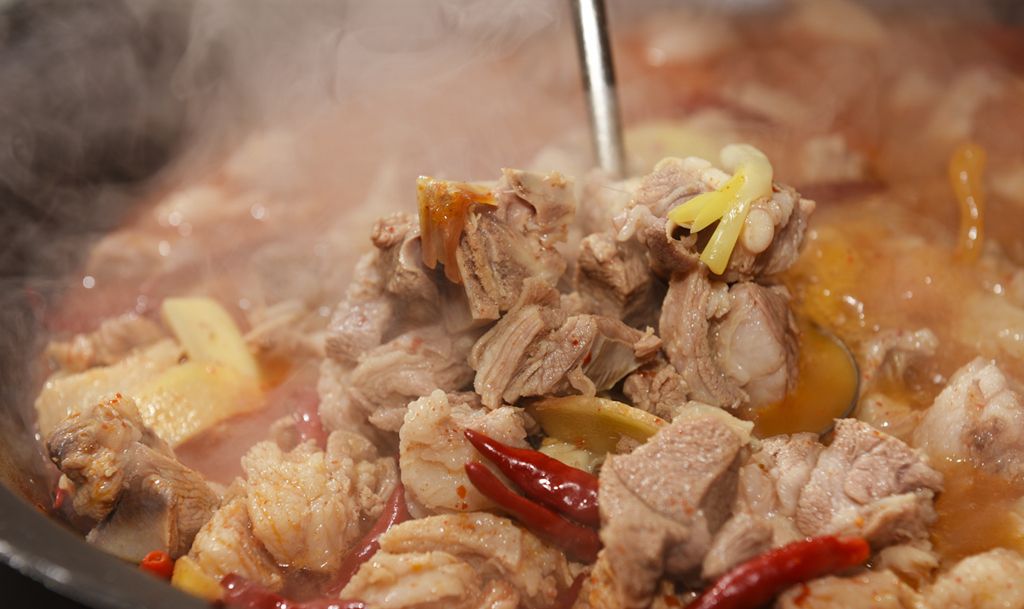 一锅热气腾腾的清炖白条羊汤正在炉灶上慢煮