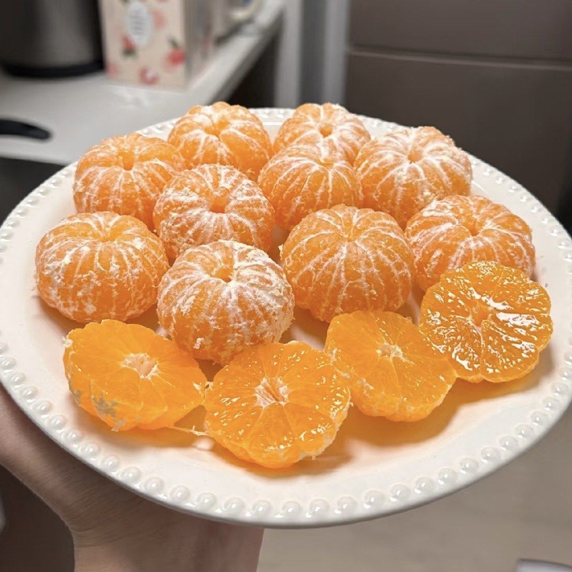 女性在家中剥开丑柑食用