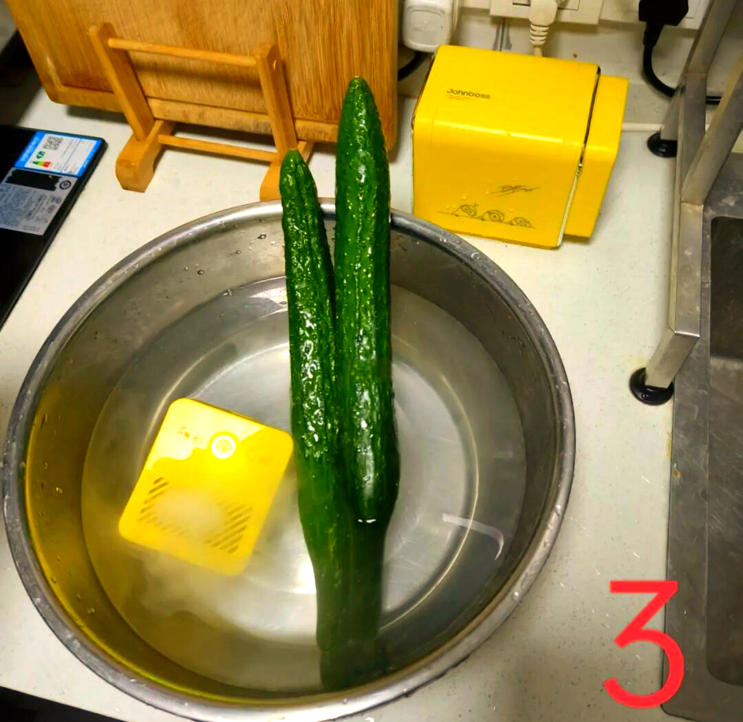 厨房操作台上摆放一个已切半的玉菇甜瓜,一把不锈钢刀正在将其切成小块,旁边配有白色瓷盘盛放切好的果肉,背景中有水龙头和蔬菜清洗篮,体现家庭日常清洗与处理过程的真实情境 玉菇甜瓜在家庭厨房中的切配场景
