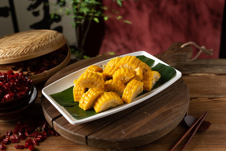 家庭餐桌上水果玉米的食用场景