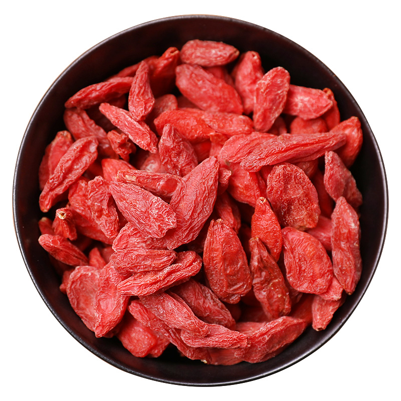 红枸杞尖创意应用：透明玻璃冷萃瓶中悬浮着数枚完整红枸杞尖嫩芽，周围环绕枸杞籽与干花瓣，液体呈淡琥珀色；旁置手冲咖啡壶与枸杞芽茶包，桌面铺陈亚麻布与木质托盘，整体风格融合东方草本美学与新消费生活方式