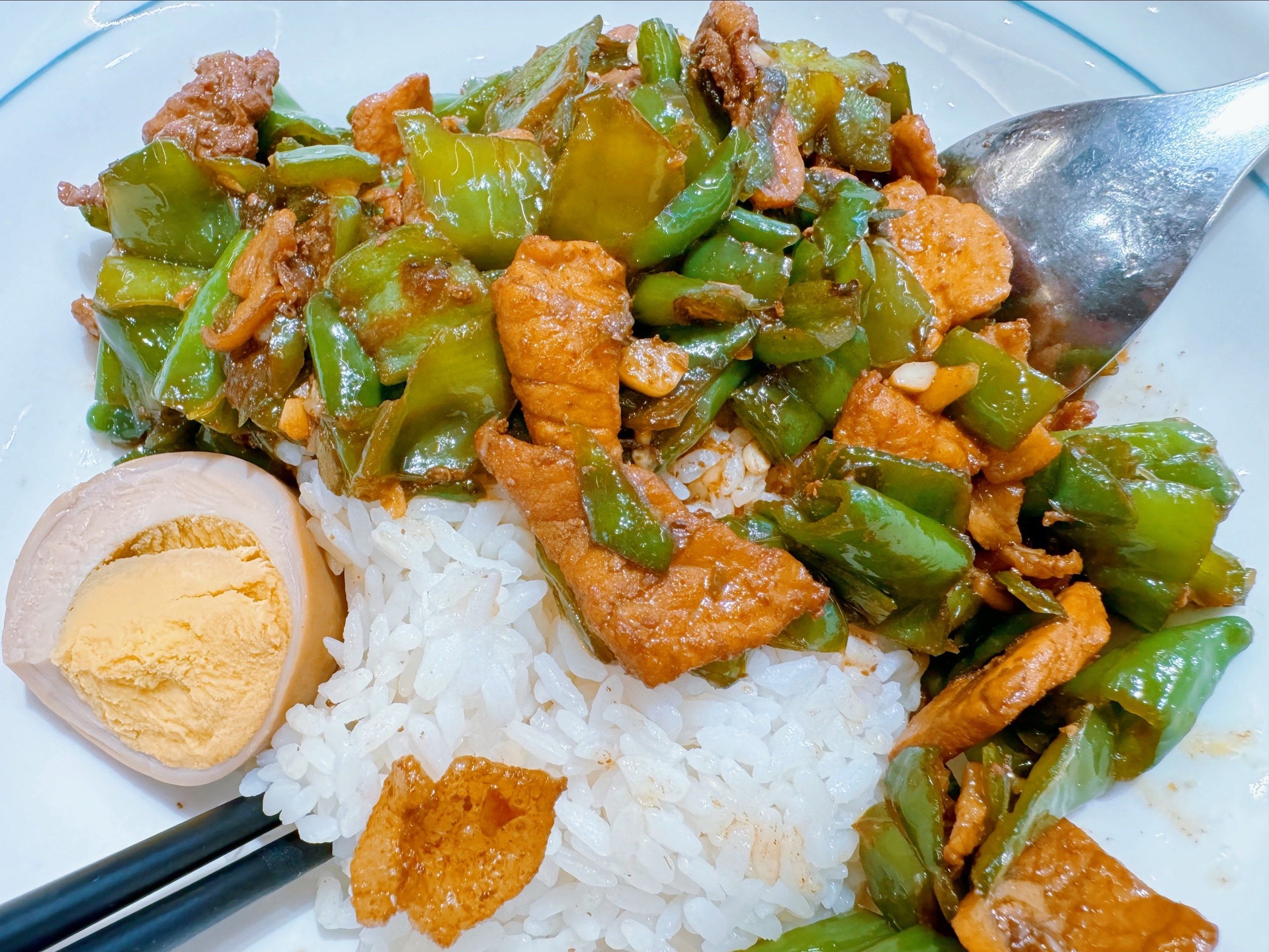 一盘刚出锅的线椒荷包蛋,色彩鲜明,热气腾腾,配有米饭 成品线椒荷包蛋特写,金黄荷包蛋与翠绿线椒交错,酱汁包裹,光泽诱人