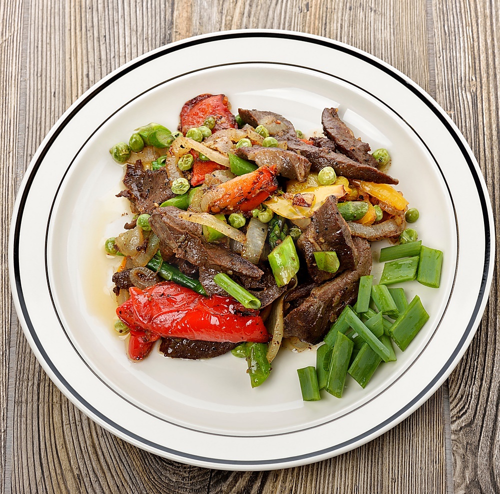 俯拍高清图:深褐色油亮牛肉粒与金黄微透洋葱丁紧密交叠,点缀翠绿蒜末,盘底有琥珀色酱汁反光,背景为黑色哑光料理盘,蒸汽氤氲 爆香洋葱牛肉粒出锅特写