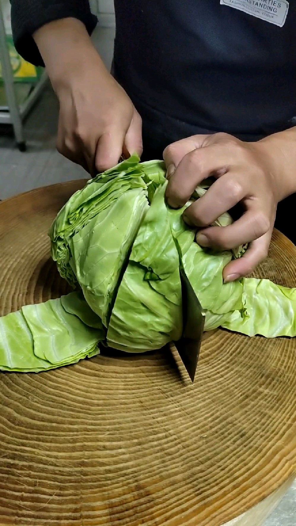 一位家庭主妇正在厨房切分松花菜,案板上摆放着完整的松花菜和已切块的部分,旁边有刀具和碗碟,背景可见冰箱和橱柜,营造出真实的生活场景 家庭厨房中的松花菜处理场景