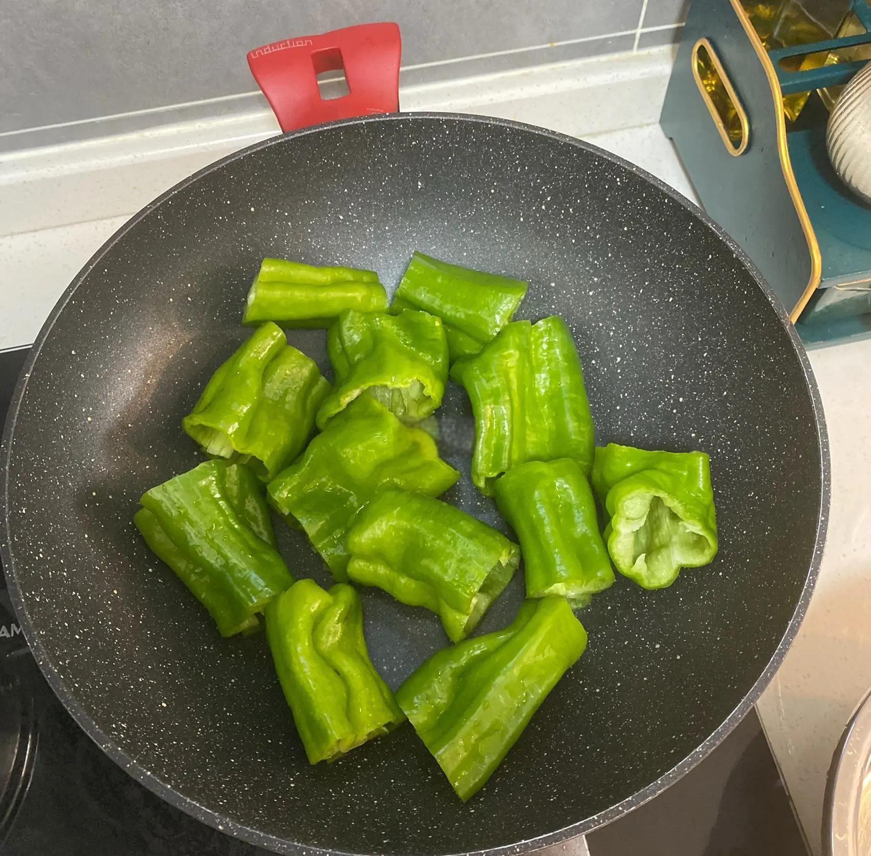 厨房中正在烹饪线椒菜肴的场景