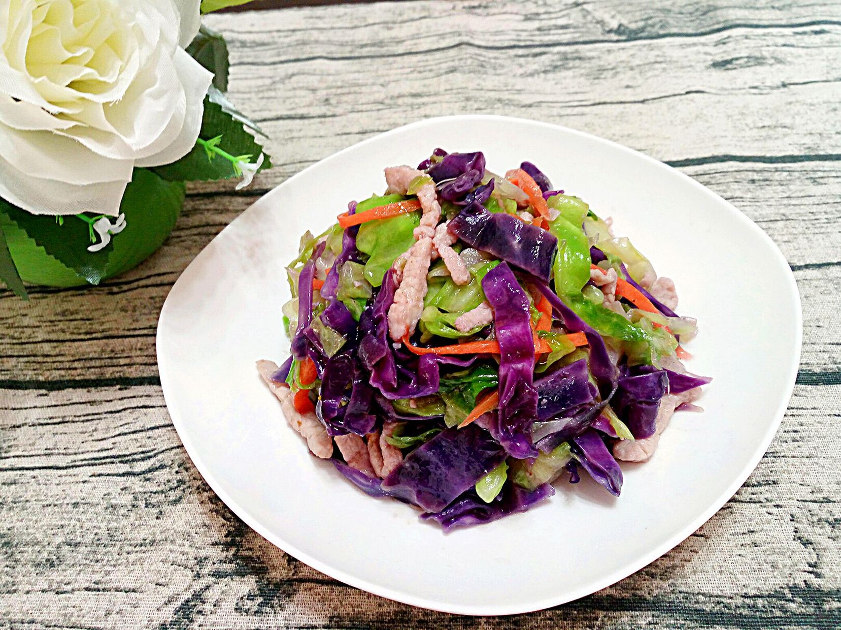 紫甘蓝炒肉与米饭搭配,盛放在餐桌上,适合家庭用餐 紫甘蓝炒肉搭配米饭食用图