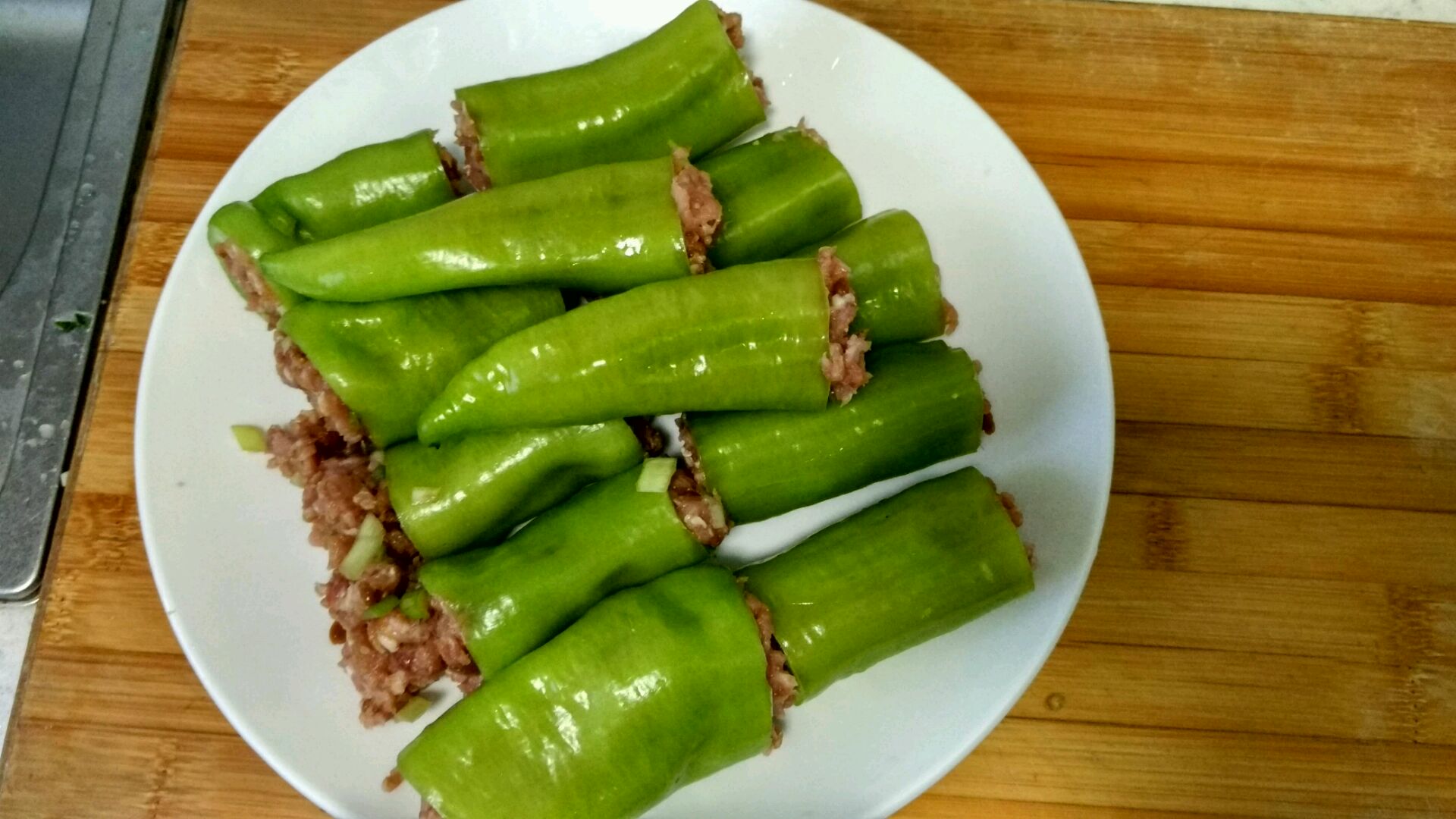 高清成品图:三只黄椒酿肉整齐摆盘,黄椒壁光滑厚实无褶皱,肉馅紧实粉嫩,表面均匀铺洒红椒细末与熟芝麻,盘底仅有少量清澈汤汁,体现‘汁丰而不泻’的工艺标准 彩椒酿肉成品特写:三个饱满黄椒“小碗”盛满粉嫩肉馅,表面点缀细碎红椒末与金黄芝麻,酱汁清亮不腻,椒壁保持完整挺括形态
