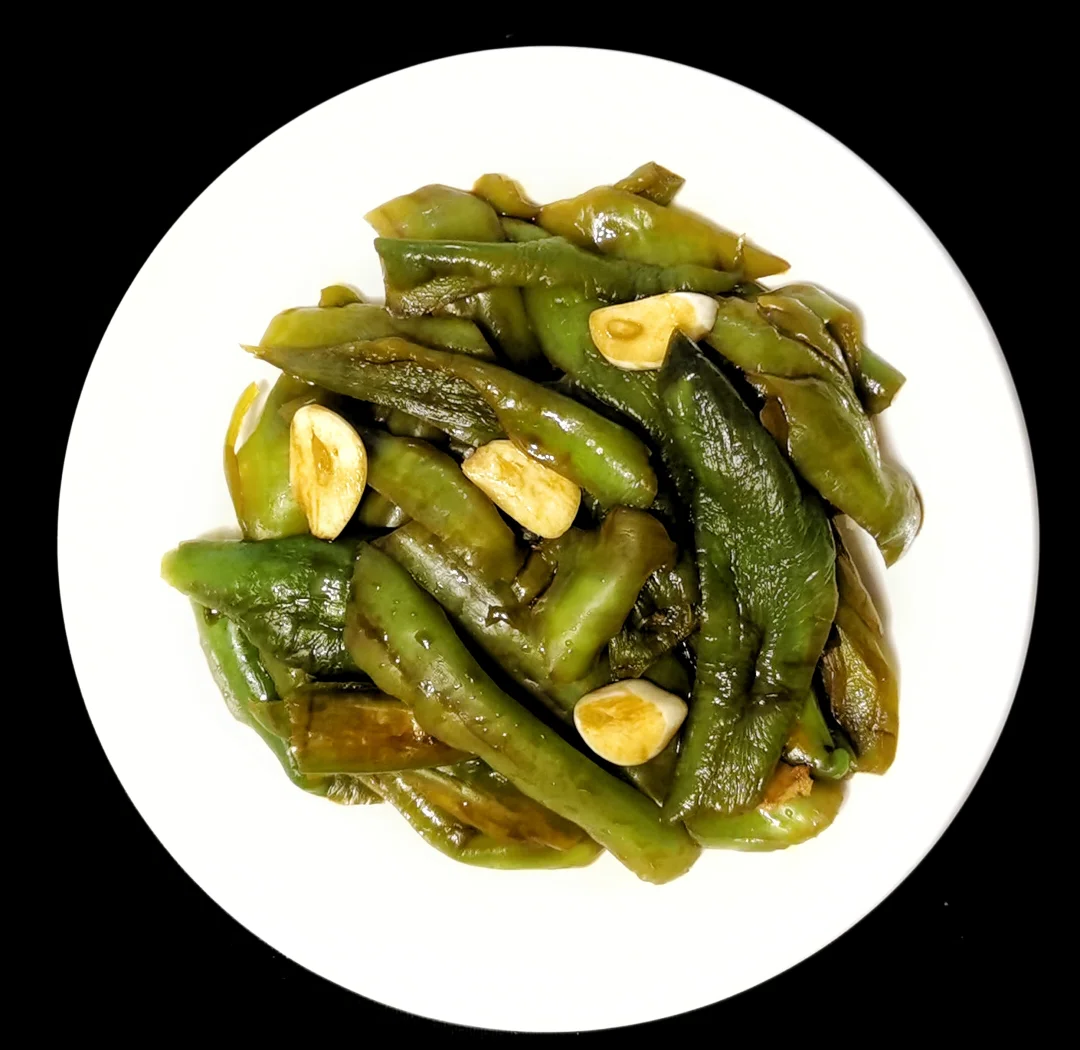 蒜蓉爆炒青圆椒成品特写：翠绿青圆椒片与鲜红椒片交织，裹着琥珀色酱汁，散落金黄蒜末与翠绿葱花，盛于青瓷浅盘中
