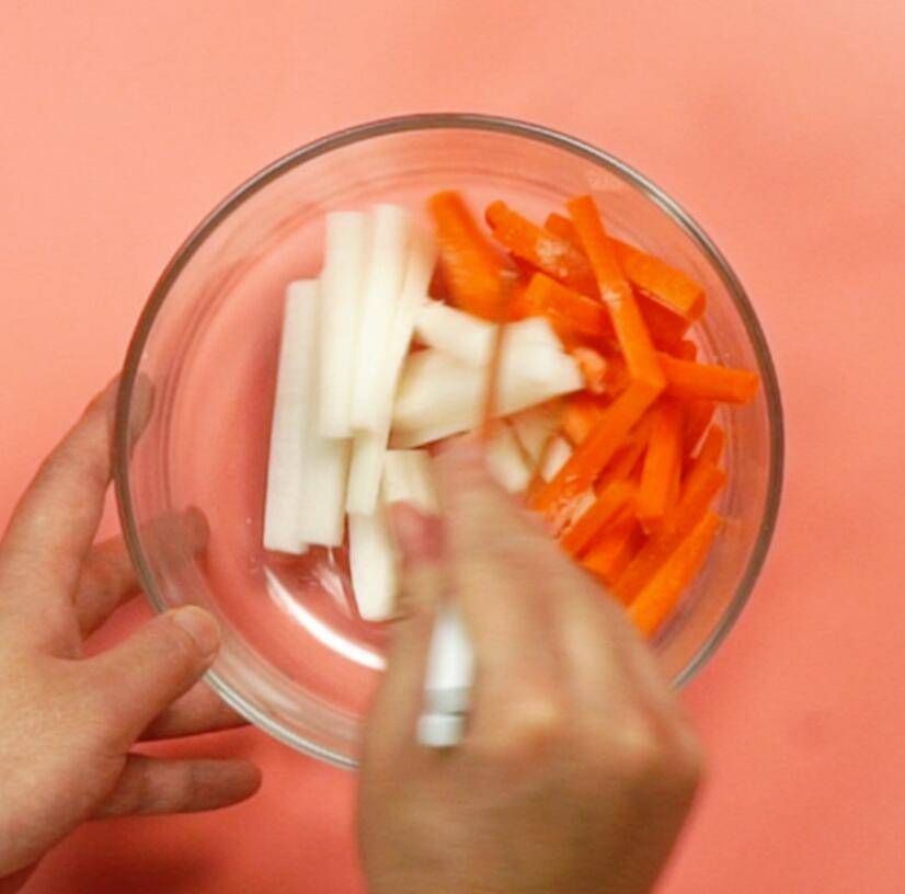 白萝卜切丝后放入碗中加盐搅拌，旁边放有计时器和食盐罐