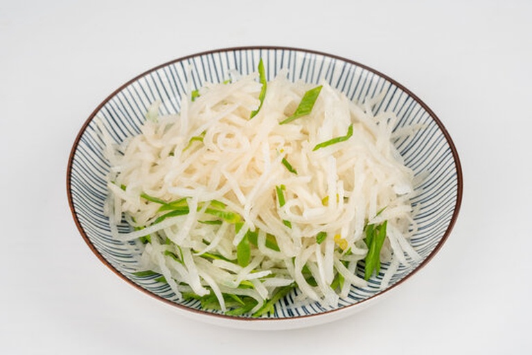 白萝卜清炒特写：新鲜脆嫩的白萝卜丝配青葱段，用铁锅快炒至半透明边缘微黄，表面油光均匀无焦糊，盘底无多余汤汁