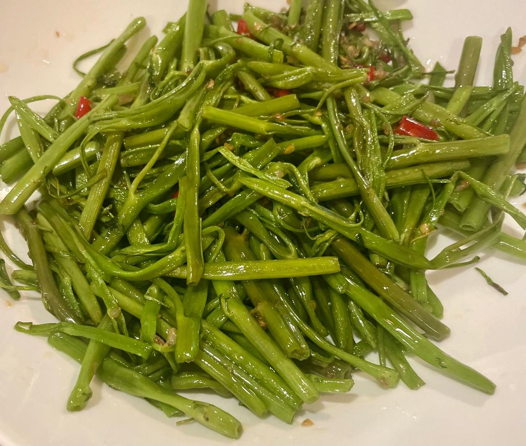 清炒锅中翻炒空心菜与生菜混合食材特写