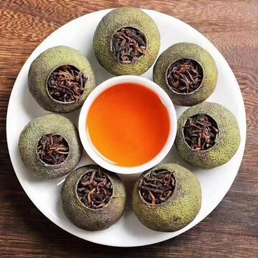 三只透明玻璃杯并列摆放,分别盛放不同冲泡次数的小青柑茶汤:第一杯浅黄明亮,第二杯橙黄透亮,第三杯琥珀色浓郁,背景为木质茶桌与柑皮碎片,展示茶汤色泽变化过程 小青柑茶汤对比图
