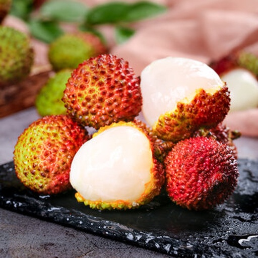 鲜荔枝特写：剥开半颗饱满红壳荔枝，露出晶莹剔透、乳白半透明果肉，果肉表面微泛水光，背景为浅木纹砧板，旁置两颗完整带绿蒂荔枝