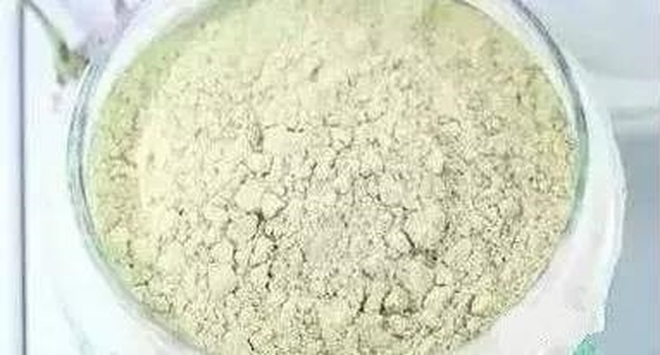 一名身穿白大褂的研究人员正在使用台式超微粉碎机处理一批浅绿色干燥豌豆壳样品,设备透明罩内可见粉末飞扬,旁边摆放着装有细粉的玻璃瓶和电子天平 实验室人员正在操作高速粉碎机处理干燥的豌豆壳原料