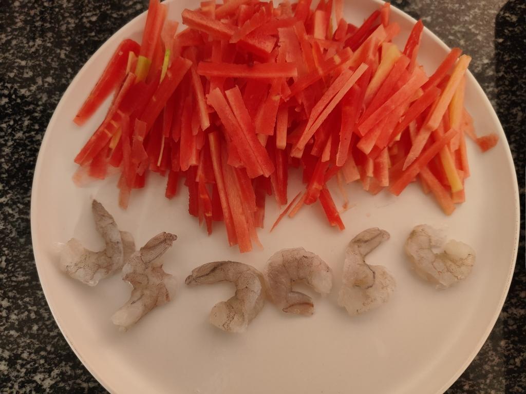 正在处理虾仁和青豌豆的食材准备过程,案板上摆放整齐 虾仁与青豌豆的处理过程