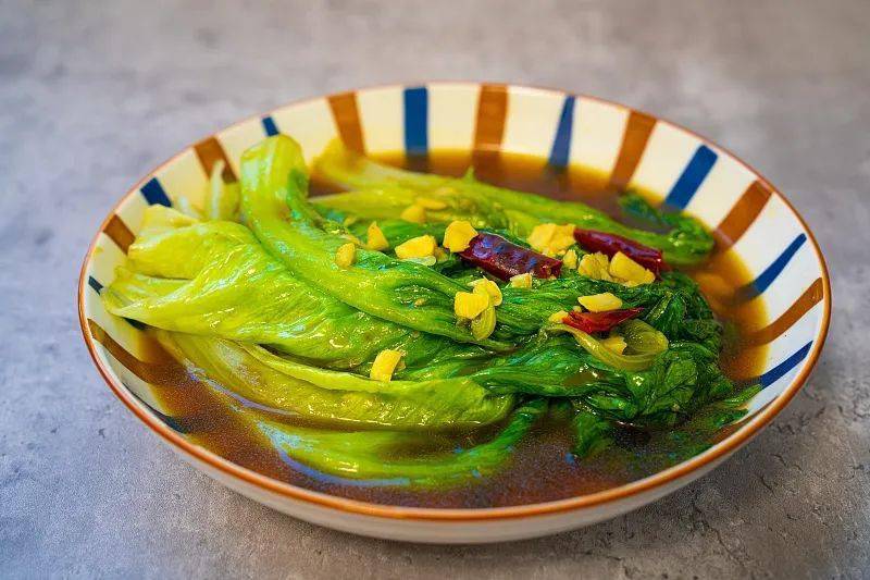 俯拍高清成品图:青翠芹菜段与乳白松花菜朵交错分布,金黄花生米均匀点缀其间;酱汁薄亮裹附不积水,撒有细蒜末与小米辣圈;餐具为哑光灰陶浅盘,衬托食材本真色泽 松花菜双脆版成品特写