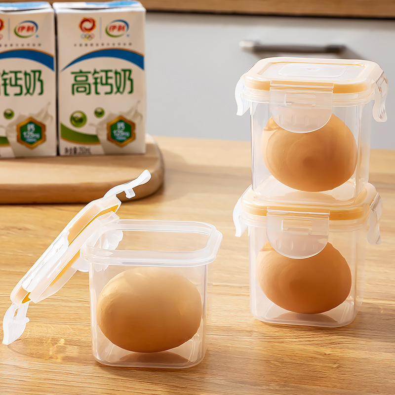 一个透明塑料蛋盒中整齐摆放着棕色外壳的新鲜鸡蛋,放置于光线柔和的厨房台面上,背景可见木质橱柜和窗户,体现家庭日常储存场景 鸡蛋储存在厨房常温环境中的实景图