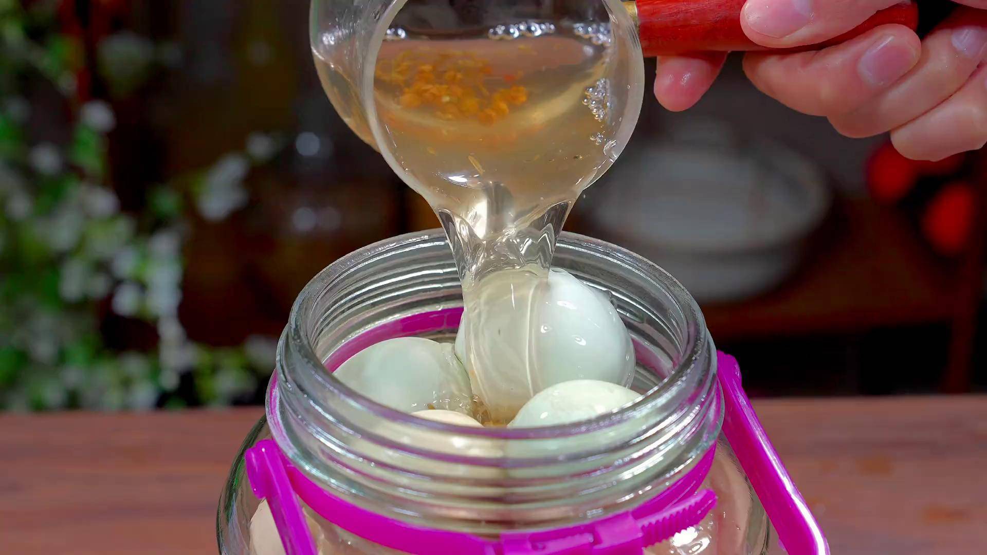 展示咸鸡蛋的腌制过程,鸡蛋被黄泥包裹并整齐摆放在容器中 咸鸡蛋制作过程