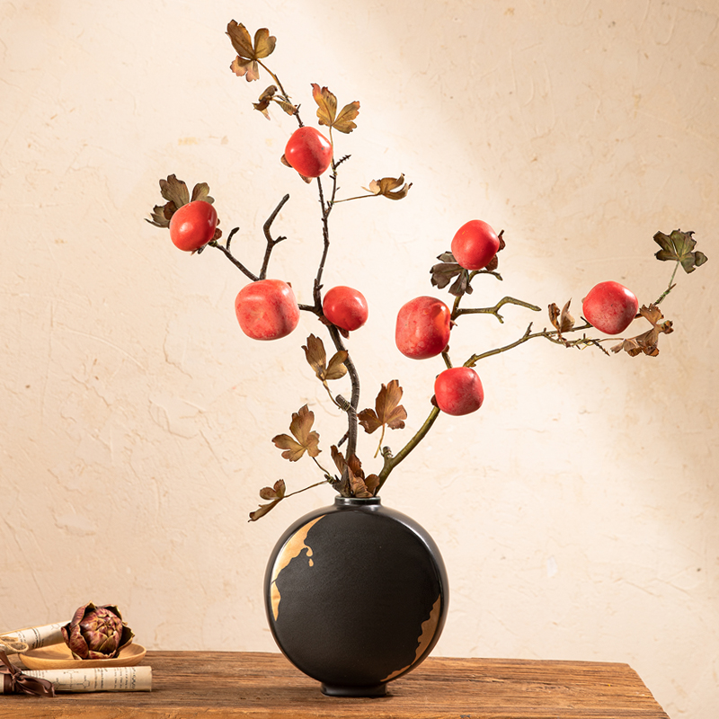 一件由青柿子染成的亚麻衬衫挂在木质衣架上，背景为竹制晾晒架和自然光线下的庭院环境