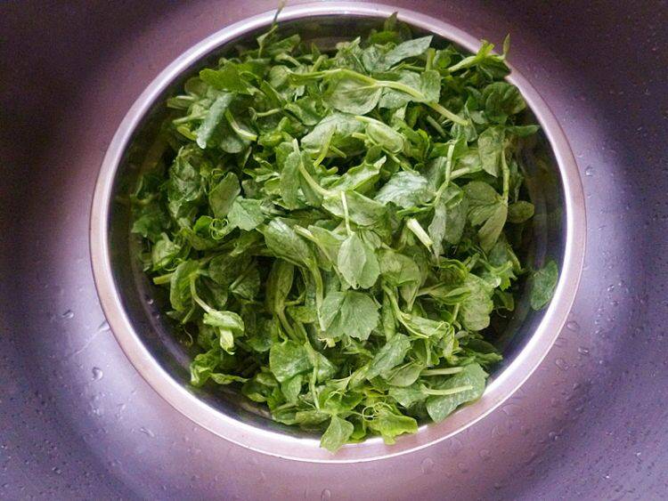 家庭厨房中正在用锅焯煮青豌豆的场景