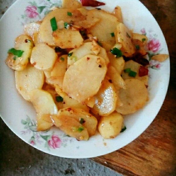 蒸土豆特写：带皮整颗黄心土豆刚出蒸锅，表皮微皱泛光泽，底部可见少量水汽凝结，盘底无油渍无焦痕