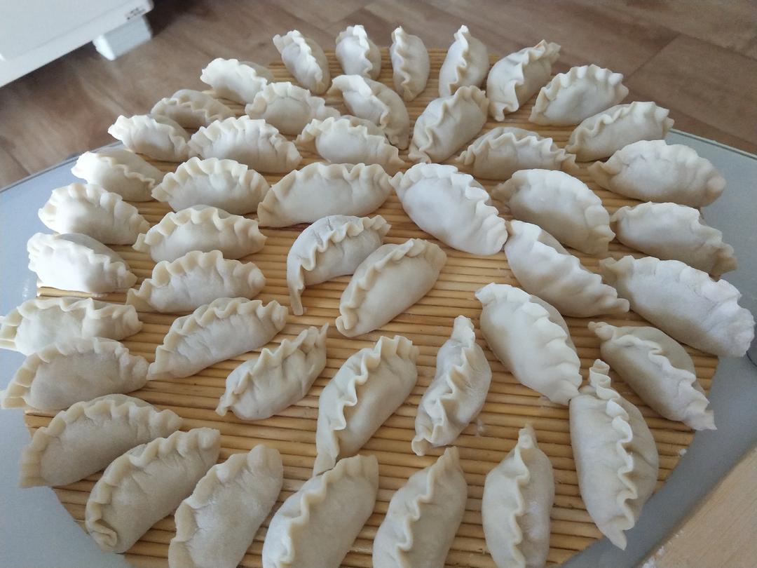 图片说明:包好的饺子整齐排列在案板上,准备下锅煮制 包好的饺子排列整齐