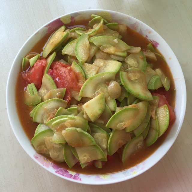 高清微距摄影:新鲜翠绿西葫芦切片与熟透红润番茄块同锅快炒,表面泛油光,可见少量析出番茄汁液包裹西葫芦边缘,无褐变或絮状沉淀,体现二者理化相容性良好 西葫芦与番茄配伍炒制特写