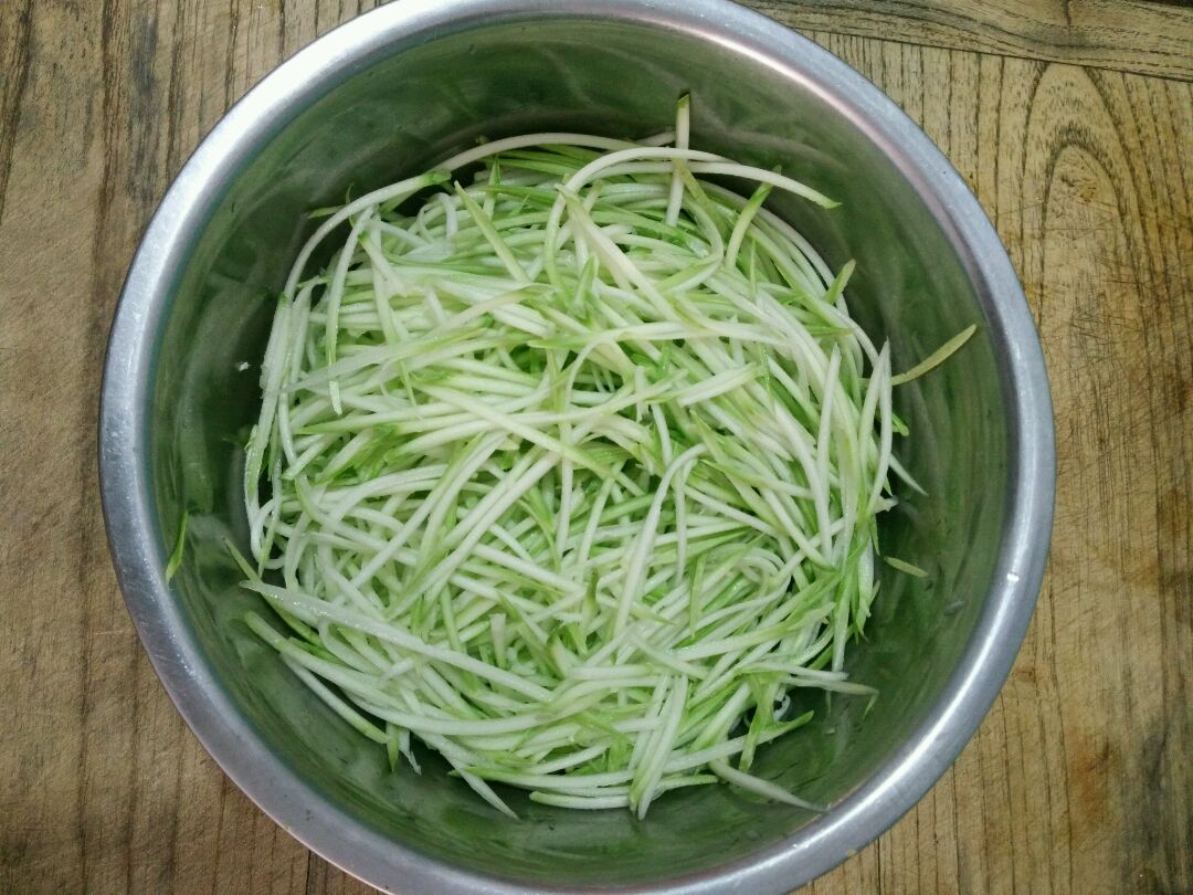 干净的砧板上摆放泡发好的海带和烹饪工具，包括刀具、碗碟和调料瓶，整体呈现家庭厨房场景