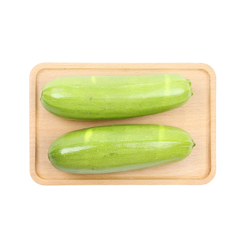 一盘切好的新鲜西葫芦摆放在木质砧板上,旁边有一整根绿色西葫芦,背景为厨房环境,光线自然,突出其作为蔬菜的新鲜质感 西葫芦是碳水化合物还是蔬菜?