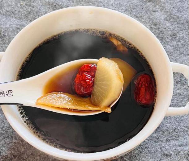 红枣葱白煮水成品视觉呈现,汤色澄明微褐,温度计标注42℃,传递‘温通’而非‘燥热’的核心饮服原则 红枣葱白煮水成品特写:琥珀色清亮汤液盛于白瓷小碗中,表面浮有细微油珠与红枣纤维碎屑,碗旁置温度计显示42℃,强调“温服”关键温度