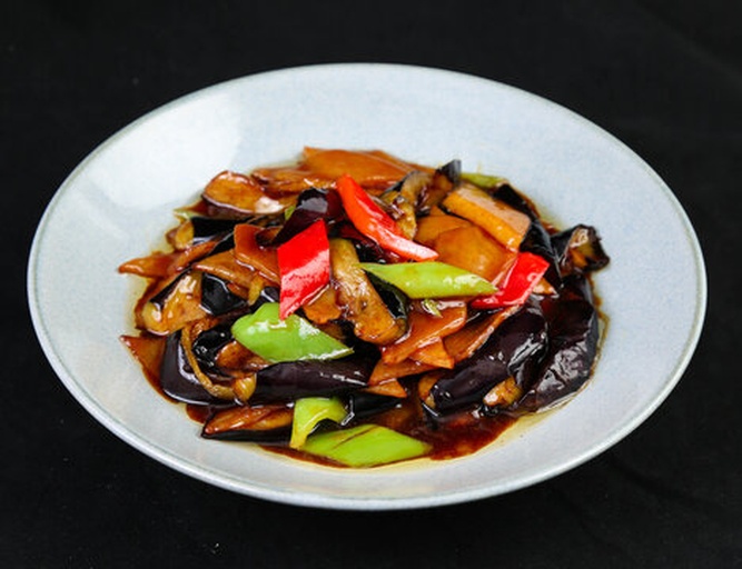 全景式中式家宴布菜图,焦点为色泽诱人的鱼香圆茄主菜,展现成品形态、酱汁包裹度及合理分量感,明确传达‘一个圆茄子够几个人吃’的终端食用效果 中式家宴摆盘:青花瓷盘中盛放红亮油润的鱼香圆茄,表面撒葱花与红椒粒,周围搭配白米饭与清炒时蔬,体现3–4人共享的温馨用餐场景