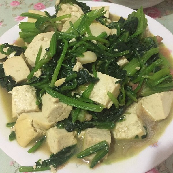一盘新鲜绿叶菠菜与几种常见腐乳(红腐乳、白腐乳、青腐乳)并列摆放,背景为木质餐桌,光线柔和,突出食材自然质感 菠菜和腐乳的食材对比图
