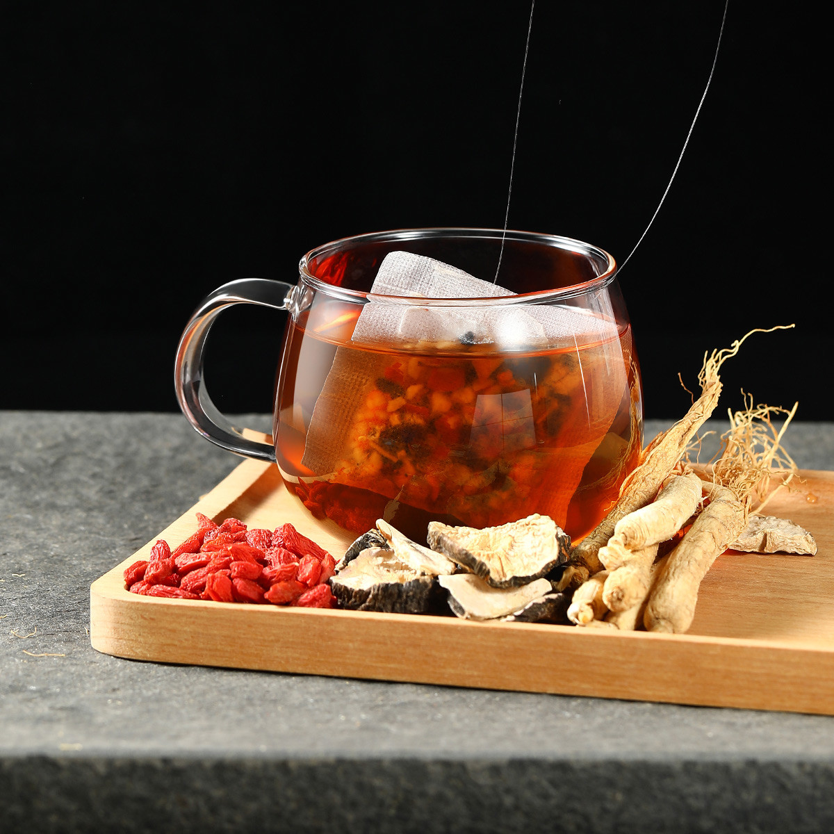 一位中年女性坐在书桌前手持透明玻璃杯饮用红参桂圆水，窗外黄昏光线柔和，桌上放有笔记本和中药材包装袋