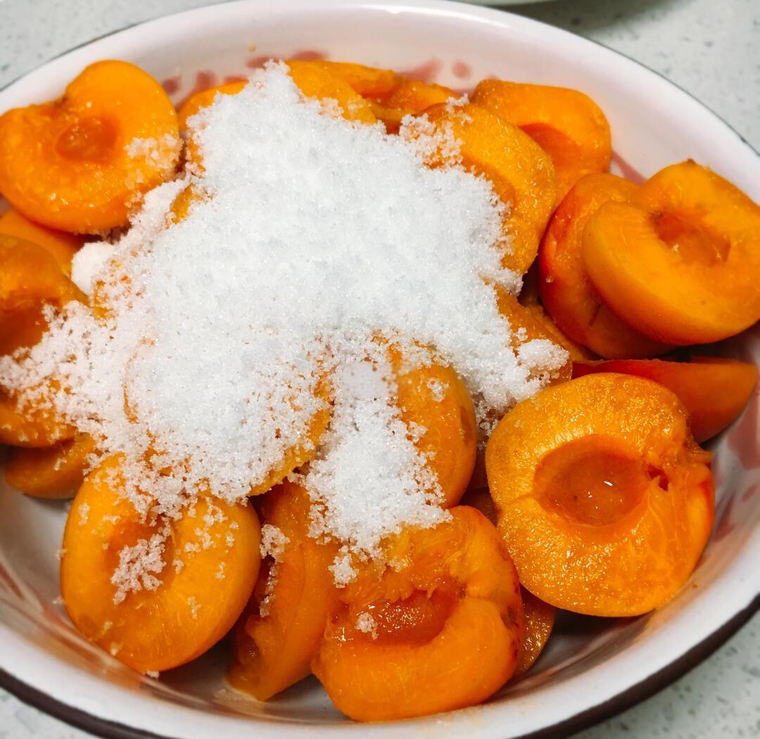 杏子在锅中与糖水一同慢煮,糖汁逐渐渗透果肉 杏子煮制过程图