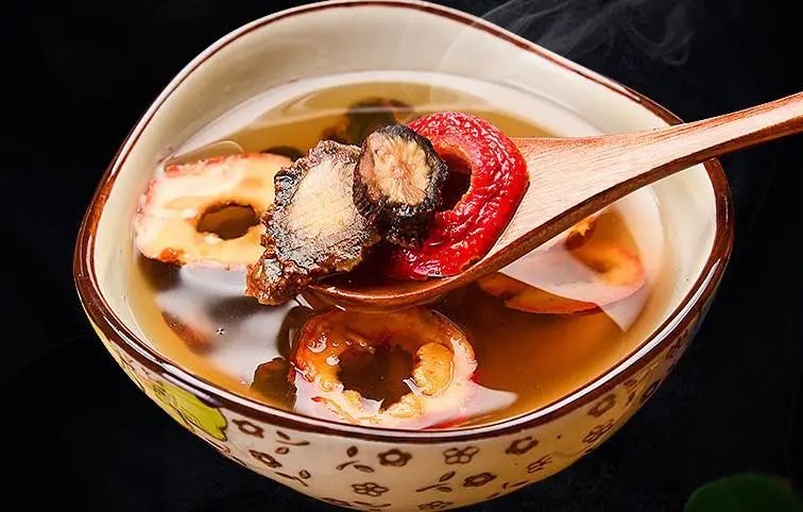 一碗刚出锅的甘麦大枣汤特写,汤色微黄清澈,碗中有数颗完整的大枣、沉底的小麦颗粒和甘草段,上方热气袅袅,旁边摆放木勺与中医养生笔记,体现自然健康的饮食方式 成品汤剂图