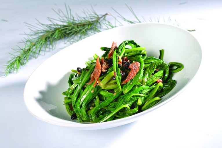 一盘色泽红亮、松花菜翠绿、肉片嫩滑的东北风味松花菜炒肉片,盛放在白色瓷盘中,背景为木质餐桌,旁边配有米饭和筷子 松花菜炒肉片成品图