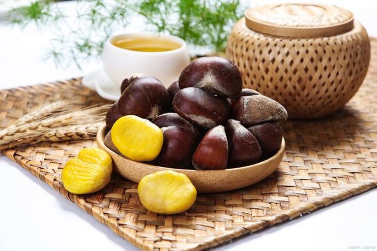 秋季栗子主题厨房场景图:突出食材新鲜度、工具质感与生活美学氛围,强化‘时令农产品’定位 秋季厨房场景图:原木操作台上摆放新鲜带壳栗子、剥好的金黄栗仁、玻璃罐装桂花蜜、铜制小锅与手写食谱本,背景虚化处可见窗外银杏叶