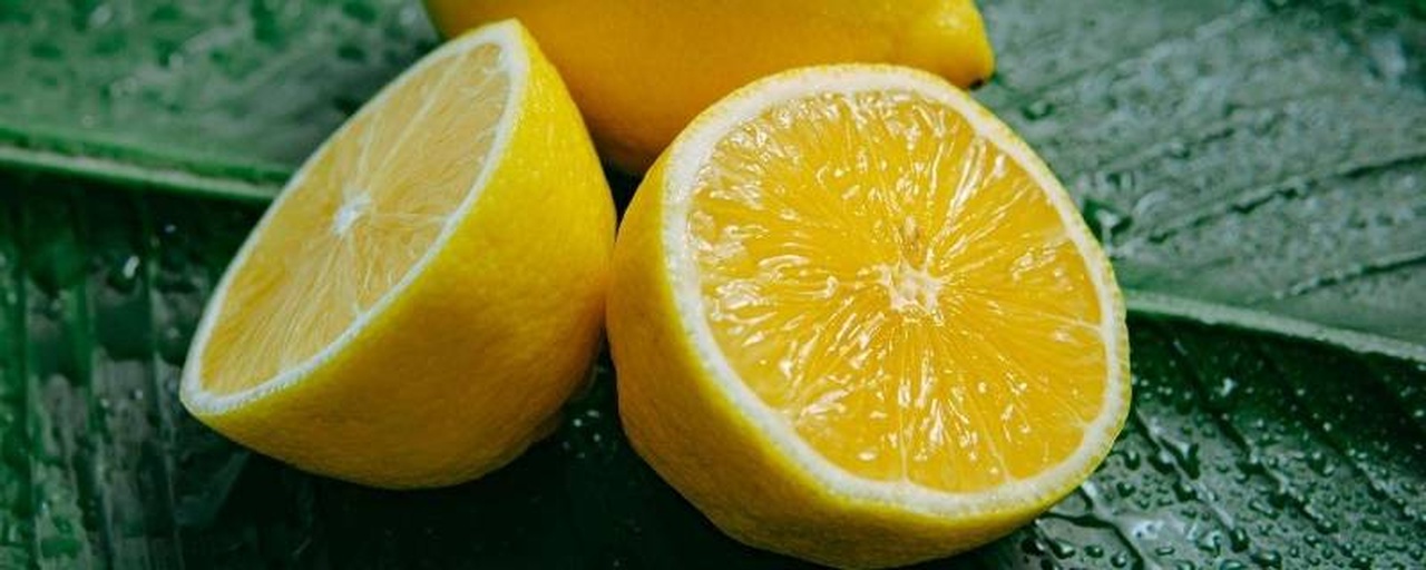高清微距摄影:成熟鲜柠檬(Citrus limon)横切面,展示果肉细胞结构、汁囊完整性及表皮蜡质层,用于说明原料新鲜度与活性成分保留关键性 鲜柠檬横切特写,果肉饱满多汁,可见清晰维管束与油胞分布,表皮呈鲜亮浅黄色,无机械损伤或霉变