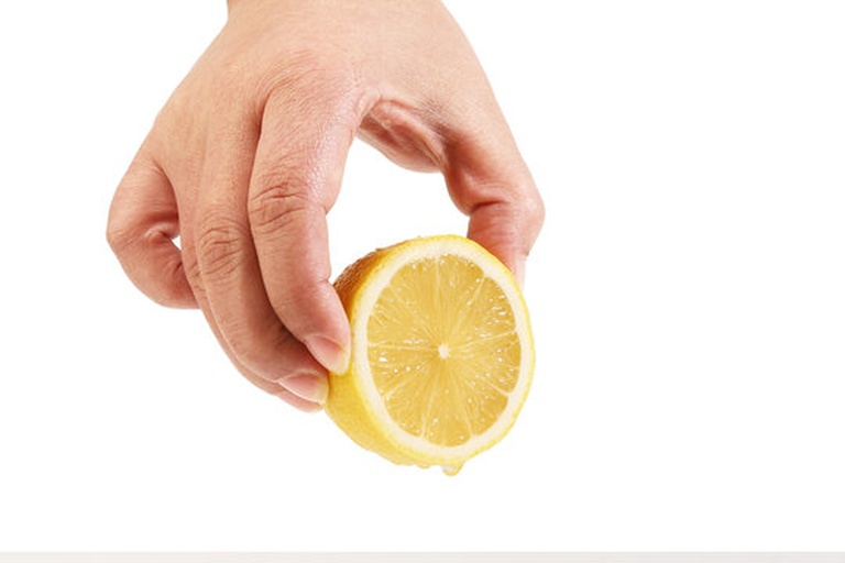 果农正在采摘柠檬,手部特写,背景是果园环境 果农采摘柠檬特写