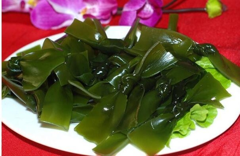 生活化实拍:刚泡发完成的干海带丝特写,质地饱满有弹性,无断碎糊烂,搭配中式凉拌调料,突出其即用性与家常健康属性 厨房场景:玻璃碗中盛放泡发后的干海带丝,色泽翠绿偏褐,根根分明、柔韧透亮;旁边摆放蒜末、香醋、芝麻与辣椒油,呈现经典凉拌海带丝备餐状态