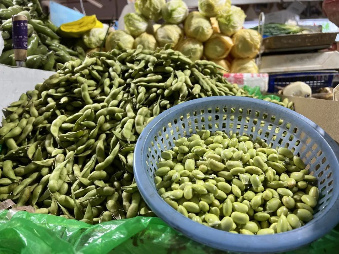 市场摊位上的毛豆销售场景