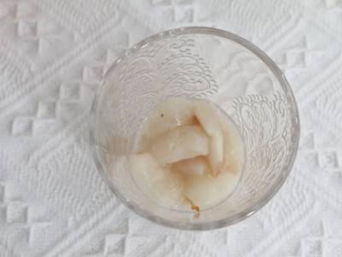 荔枝与清水放在桌上,旁边放着漱口杯 荔枝与清水漱口的对比图